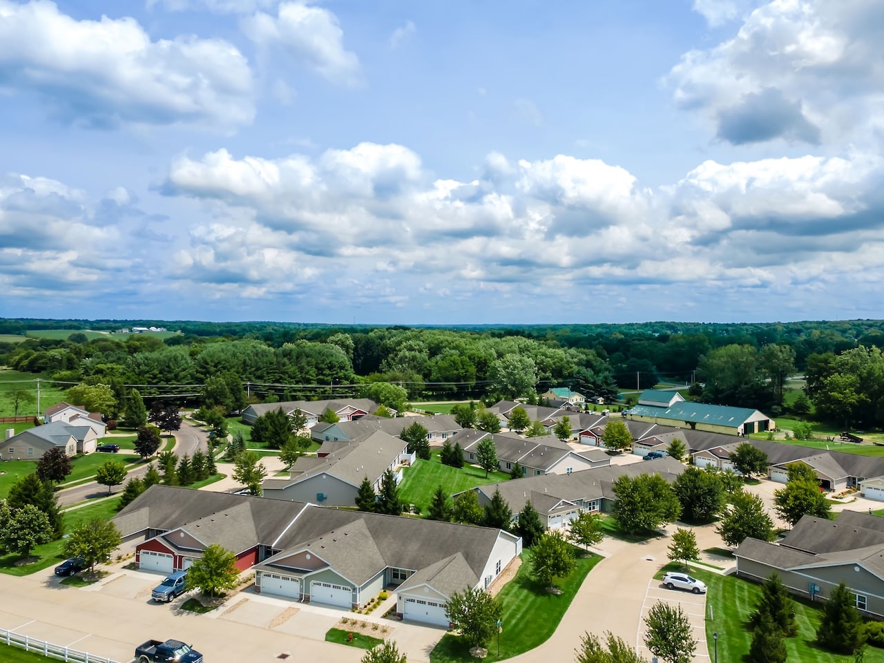 A group of houses with trees and blue sky.