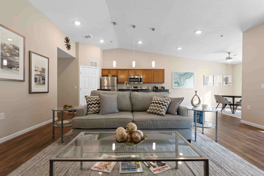A living room with a couch and a glass coffee table.